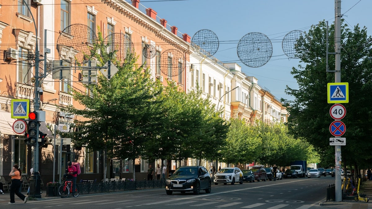 A city street lined with buildings and trees.